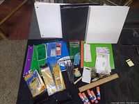 Photo showing assortment of binders, notebooks, pencils, pens, glue sticks, ruler and paper clips