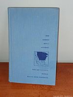 Front cover of the blue cloth vintage field guide book showing categories and a North America map illustration.