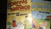 Two vintage Dennis the Menace comic books side by side, showing the covers with title, character images, and colors.
