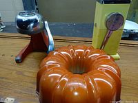Photo of all three vintage kitchen items: ice shaver, juicer, and bundt pan.