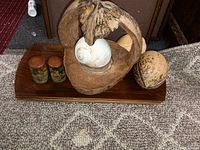 Full view of lot showing carved coconuts, salt and pepper shakers on wooden tray base