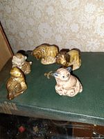 View showing entire lot of five Wade pottery animal figurines placed on a green book.
