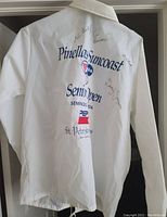 Back of white jacket showing large blue and red printed text for Pinellas Suncoast Senior Open, Pepsi logo, and St. Petersburg Times. Multiple signatures in black pen on fabric.