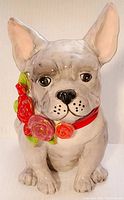 Front view of the glossy porcelain bulldog figurine showing detailed facial features and the floral collar.