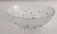 Side angle view of clear textured hobnail glass bowl with colorful raised raindrop pattern.