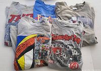 Five Marvel T-shirts folded showing varied comic and character graphics on fronts