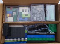 Top view of plastic containers and bag with assorted LEGO bricks and base plates