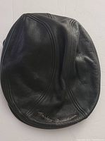 Front view of black leather hat with Harley Davidson embroidery visible on the back.