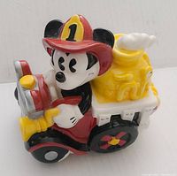 Side view of the Mickey Mouse fire truck music box showing Mickey sitting at the wheel with clear details and vibrant colors.