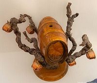 Overview of the piece showing gnarled branches holding miniature copper buckets and wooden base.