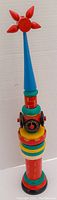 Full view of colorful wooden clock tower figurine with red star at top