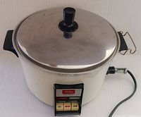 Full view of the vintage Toshiba RC-6LH rice cooker showing the stainless steel lid, black plastic side handles, and front control panel with buttons.