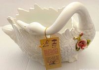 Porcelain swan centerpiece with attached original tag tied around neck showing brand marks and Italian text detailing handcrafted production by Antonio Zen at Nove factory.
