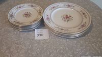 Photo showing stacked plates on table: 4 larger dinner plates and 6 smaller salad plates.