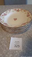 Stack of six white porcelain bowls with pink rose floral pattern and gold rim, shown to illustrate the quantity and design of the lot.
