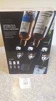Front view of boxed Oscillot automatic drink dispenser for three inverted liquor bottles