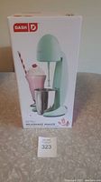 Front view of the boxed Dash Retro Milkshake Maker showing the product image and branding.