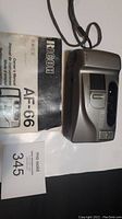 Photo of Ricoh AF-66 camera with user manual and lot tag.