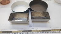 Set of 4 vintage bakeware pans: 2 round springform and 2 rectangular loaf pans, viewed from above with measuring tape for scale.