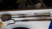 Set of three vintage gardening tools arranged side by side, showing full length against a measuring tape indicating about 30 inches each. Tools have wooden handles and metal ends showing rust.