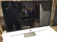 Front view of 27-inch Apple iMac computer, showing black screen and Apple logo on front bezel.