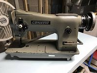 Side view of Consew sewing machine mounted on metal table