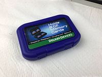 Closed blue Delkin Devices case for CompactFlash cards showing labeling on lid.