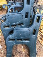 Close-up of two green plastic molded bench ends labeled 'SDM INC' showing scratches and dirt.