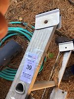 Close-up of ladder top section showing aluminum construction and sale lot tag.