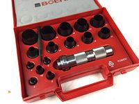 Open red Boehm branded plastic case showing knurled metal handle and 14 cylindrical hollow punches of various sizes.