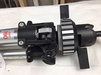 Close-up of the tripod head and adjustment knobs showing mounting assembly and locking mechanisms.