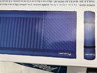 Blue sleeping pad fully unrolled showing texture and compact rolled version beside it