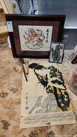 Photo showing the framed dragon painting, ceramic tile, and the vintage 1981 calendar page with Asian female artwork in traditional clothing.