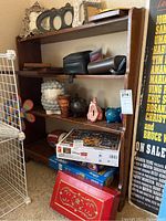 Shelf holding multiple items including boxed Disney puzzles and a decorative red box