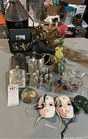 Full view of all items on table including masks, figurines, flask, and decorative pieces