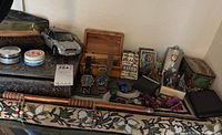 Overview of all lot contents on tapestry, including watches, toy car, cufflinks and miscellaneous items