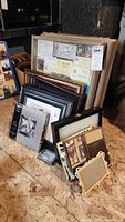 Shadow box frames and photo frames stacked together, showing varied sizes and styles