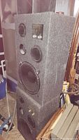 Two Acoustic Response Series 707 speakers stacked, showing front drivers and brand plate on upper speaker