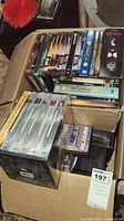Wide view showing various DVDs stacked in a box including Star Trek, Simpsons, Lord of the Rings, Scream, Bourne Identity and others