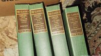 Set of four Greek volumes with titles Poetry, Biography/Oratory/Science, Epic Literature II, and Epic Literature I.