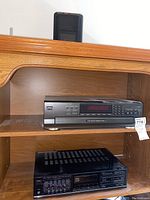 Technics SL-PD6 CD changer and Fisher stereo tuner on wooden shelving unit