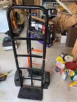 Photo of two hand trucks dollies standing upright, showing frames and platform base.