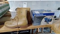 Photo of the tan work boots next to the original box of Power Fist electric hand planer.