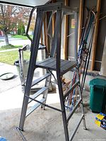 Overall view of the aluminum step ladder showing the platform and supporting cross bars.