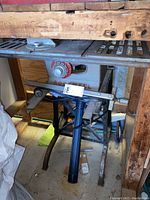 Three photos showing the Rockwell table saw from different angles including close-up of brand name and adjustment dial, lower stand with dust collection port.