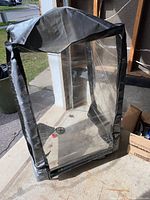 Snow blower weather protector cover with clear plastic panels and gray fabric.