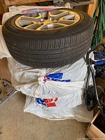 Four Goodyear Assurance tires stacked on one another, mounted on silver alloy rims with a multi-spoke pattern.