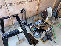 Wide shot of all tools and items including metal stand, heat lamp, drill, hand tools, hardware boxes