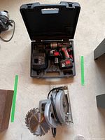 Duramark circular saw with blade attached and extra saw blade laying next to it.