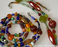Two antique Asian stone bead necklaces coiled and arranged to show variety of beads